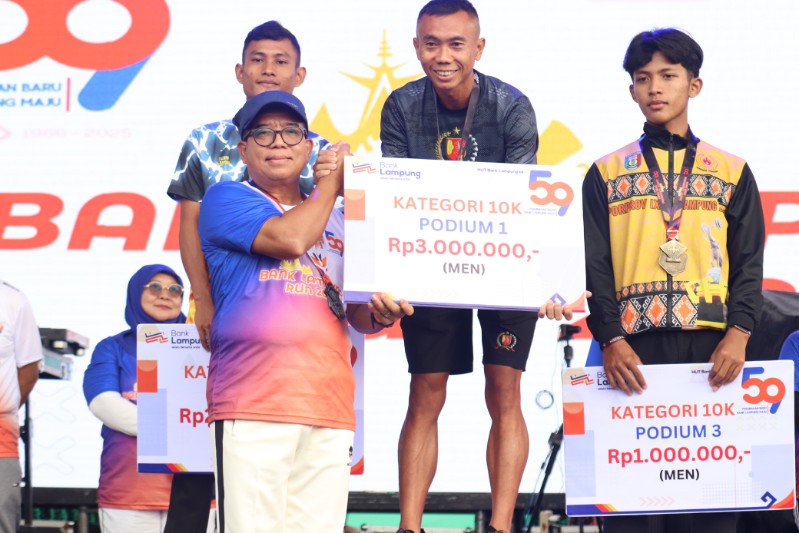 Penjabat Gubernur Lampung, Samsudin, menyerahkan hadiah kepada pemenang 10K pria Bank Lampung Run 2025 di Tugu Adipura, Ahad (9/2/2025). (Diskominfotik Lampung)