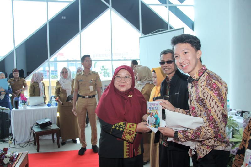 Pj Bunda Literasi Lampung, Maidawati Retnoningsih, menerbitkan buku "Terjebak di Puncak" di Dinas Perpustakaan dan Kearsipan Lampung, Senin (10/2/2025). (Diskominfotik Lampung)