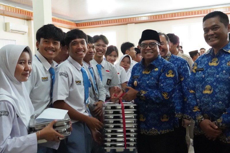 Pj Gubernur Lampung, Samsudin, menyerahkan Makan Bergizi Gratis kepada para siswa SMAN 1 Bandarlampung, Senin (17/2/2025). (Diskominfotik Lampung)