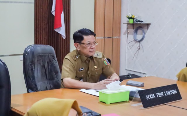 M. Firsada menghadiri penyerahan bantuan sapi kurban secara daring dariRuang Command Center Lantai I Dinas Kominfotik Lampung