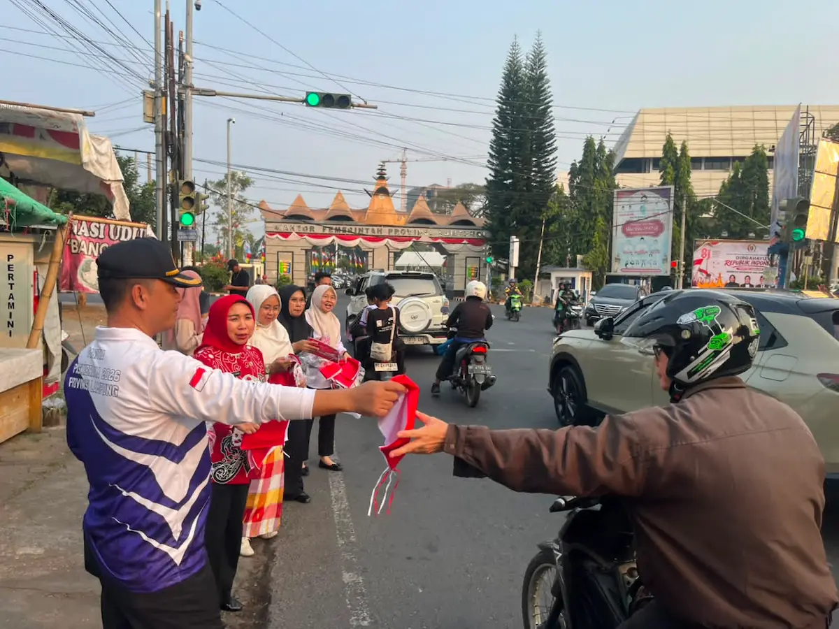 Badan Kesbangpol bersama jajaran OPD membagikan bendera Merah Putih kepada pengendara di depan Kantor Gubernur Lampung