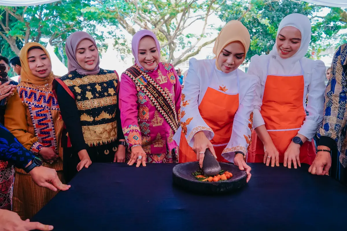 Ketua TP PKK Lampung Purnama Wulan Sari Mirza ngulek sambal pada ajang Seruit Battle, rangkaian Festival Krakatau XXXV di Lapangan Saburai