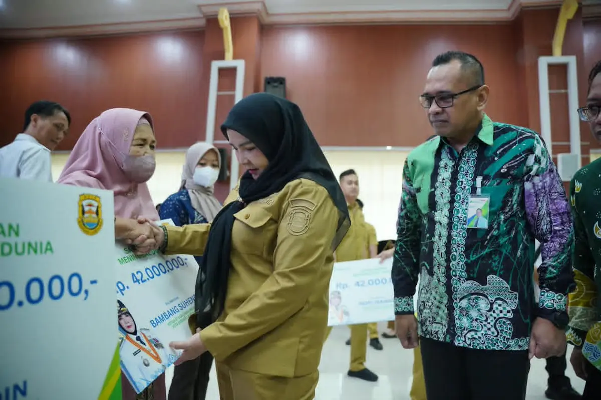 Wali Kota Bandarlampung, Eva Dwiana menyerahkan kepesertaan BPJS Ketenagakerjaan kepada pekerja rentan, Ketua RT, Ketua Lingkungan, dan anggota Linmas