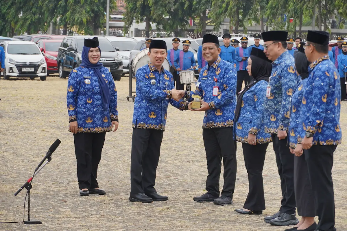 Sekdaprov Lampung Marindo Kurniawan menyerahkan SAKIP Award Provinsi Lampung 2026 kepada OPD usai upacara Sumpah Pemuda di Lapangan Korpri.